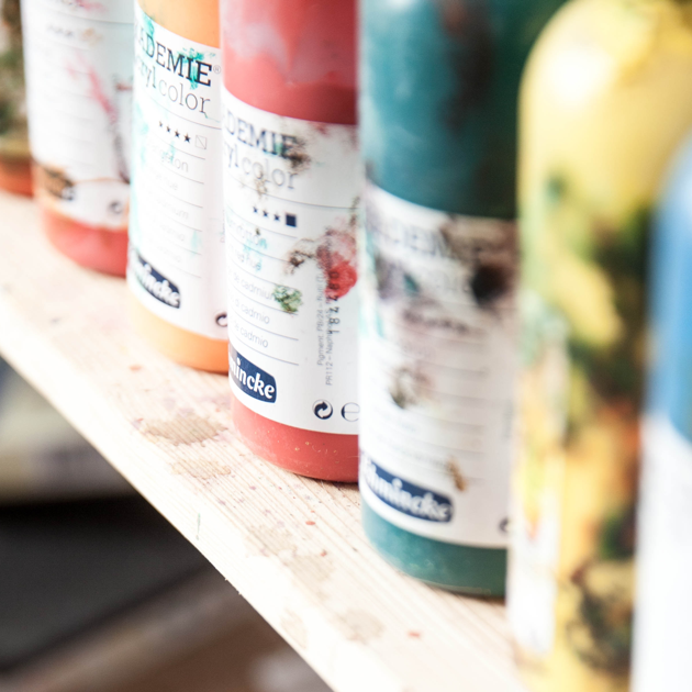 Paint bottles of different colours on a shelve