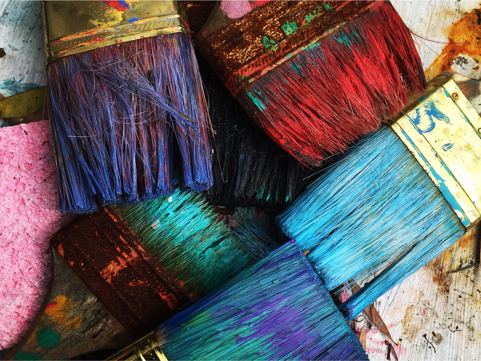 Pile of paint brushes filled with paint